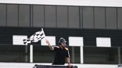 Stock car race official waves checkered flag Stock Footage