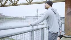 Attractive ethnic male exercising/stretching outdoors Stock Footage