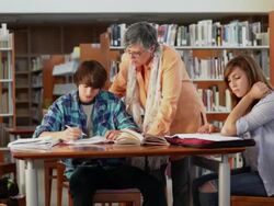 MS Teacher helping two students in library / Santa Fe, New Mexico, United States Stock Footage