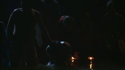 Hindus splash water over themselves as they bathe together in a river at night. Stock Footage