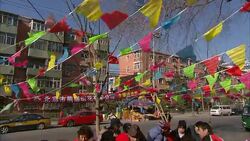 Vendors sell fireworks under a multicolor flag banner in Beijing, China. Stock Footage