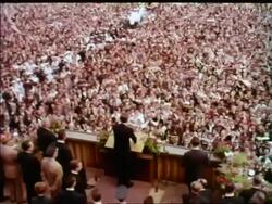 1963 high angle REAR VIEW President John Kennedy at podium making speech to cheering crowd / Berlin Stock Footage