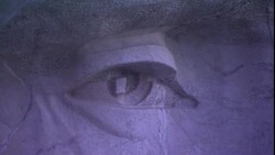 Cracks in the rock on Mount Rushmore run across the face of a carved image of a U.S. President. Stock Footage