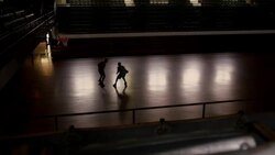 Two men play basketball together in a dark gymnasium. Stock Footage