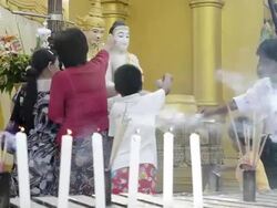MS Shot of local people pouring water on Buddha likeness and candles and incense burning in shwedagon pagoda / Yangon, Yangon Division, Myanmar Stock Footage
