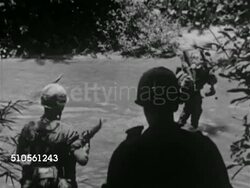 1965: VIETNAM WAR: WS Explosion over field, large smoke cloud, soldiers firing mortars, WS Large smoke cloud in field, foxhole, explosion, U.S. Soldiers crossing creek, walking through jungle, South Vietnamese soldier w/ U.S. Troops. Vietnam Conflict Instructional Video