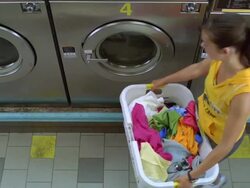 MS Young lady places clothe from basket into machine / New York, New York, United States Stock Footage