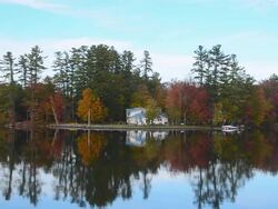 WS View of beautiful fall scene of Lake Pennasseewassee with summer homes and fall colors in leaf peeping October with reflections in water in Northern New England / Norway, Maine, United States Stock Footage