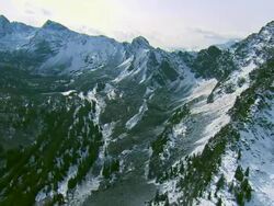High altitude flight among snow-covered peaks of the Spanish Peaks mountain range near Big Sky, MT to reveal Spanish Lakes below Stock Footage