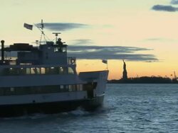 WS View of ferry passing by Statue of Liberty in UNESCO World Heritage Site at sunset / New York City, New York, USA Stock Footage
