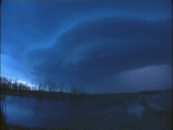 Time lapse WA Thunder and Lightning in blue twilight sky, Over water with causeway going in to distance, USA Stock Footage