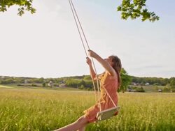SLO MO Girl swinging in the meadow Stock Footage