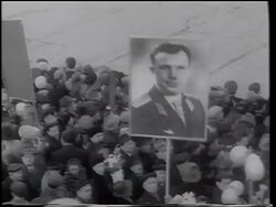 B/W 1961 high angle crowd holding poster with photograph of Yuri Gagarin / celebration of his space flight Stock Footage