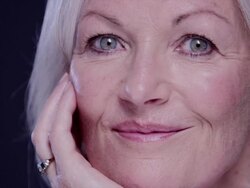 CU senior woman head resting on hand looking and smiling to camera Stock Footage