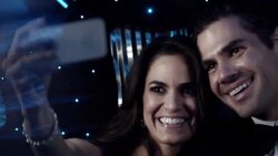 Happy couple in limousine laugh as they take photos with smartphone at awards show Stock Footage