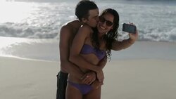 Young couple taking self-portrait with camera phone on beach Stock Footage