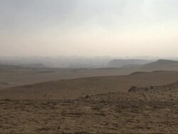 Wide Shot, tracking-left - The Great Pyramids tower above the Giza Plateau / Egypt Stock Footage