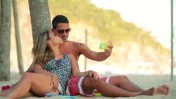 Young Brazilian couple take selfie and kiss under palm tree on Rio beach Stock Footage