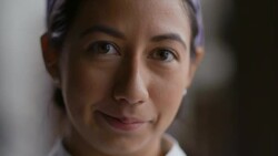 Female pastry chef blinks and stares into camera Stock Footage