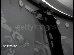 1942: WASHINGTON, D.C.: Sailor adding information to top of world wall map. US Army & Navy officers standing, looking over papers in front of world wall map. WWII Instructional Video