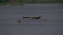 Long shot of fisherman climbing into canoe at dusk Stock Footage