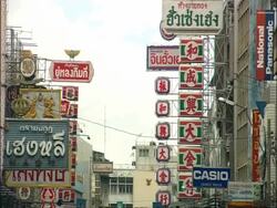 Street signs in Thai, tilt down to busy street, Bangkok, Thailand Stock Footage