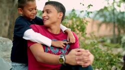 Hispanic teenager talks and laughs with younger brother Stock Footage