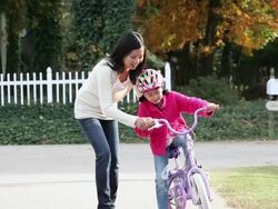 MS PAN ZO Mother teaching young daughter how to ride bicycle / Richmond, Virginia, United States Stock Footage
