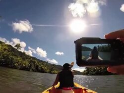 A man taking a picture of a woman kayaking at Raiatea Island on the Faaroa River, the only navigable river in French Polynesia. Stock Footage