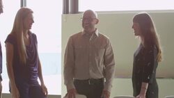 MS Smiling businesswoman leading project discussion during informal meeting with colleagues standing at office conference table Stock Footage