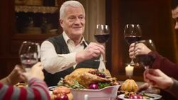 Grandfather clinking glasses with his family at Thanksgiving table Stock Footage