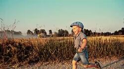 SLO MO Little boy running on a dirt road Stock Footage