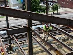 A steelworker grabs a swinging beam at a construction site Stock Footage