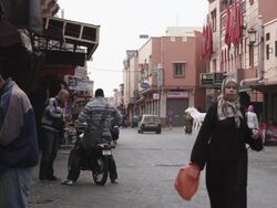 MS Shot of people walking and vehicles moving on street / Marrakesh, Morocco Stock Footage