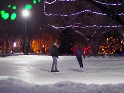 Couple has skating date on a snowy winter evening. Stock Footage