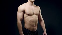 healthy athlete shows good muscle on black background Stock Footage