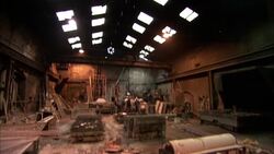 Light shines through skylights in the ceiling of a busy workshop as a pulley support rolls along just below. Stock Footage