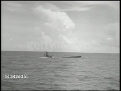 1940s: UNITED STATES NAVY:  VS U.S. Navy submarine surfacing in the Pacific Ocean, moving at sea, submariner on tower on lookout w/ binoculars. WWII, World War II, Pacific Front, Salmon-class sub Instructional Video