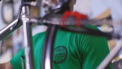 Bike mechanic cranks pedal by hand and inspects bicycle chain and spinning wheel Stock Footage