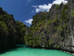 "WS tilt down to idyllic tropical lagoon surrounded by plants and sharp limestone cliffs / Small Lagoon, Miniloc Island, Bacuit Archipelago, El Nido, Palawan, Philippines" Stock Footage