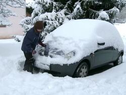 WS Girl removing snow from car / Saarburg, Rhineland-Palatinate, Germany Stock Footage