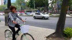 MS TS Woman commuting on bike on city sidewalk Stock Footage