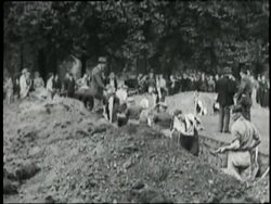 Men use shovels and pick axes to dig trenches. News Clip