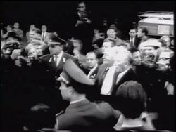 B/W 1961 PAN from Konrad Adenauer + others moving thru crowd to Brandenburg Gate / Berlin Stock Footage