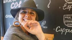 Cute girl standing in front of a black board filled with drawings and scribbles and looking at camera Stock Footage