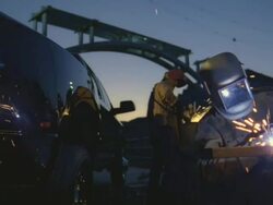 MS Man arc welding next to truck beside under construction bridge at Hoover dam / Mojave, California, USA Stock Footage