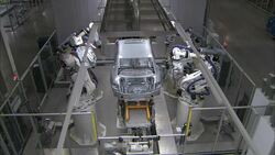 Robots flank an automotive assembly line. Stock Footage