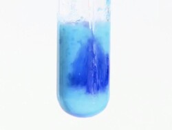 Ammonia added to a precipitate of copper (II) hydroxide. The presence of the ammonia causes the formation of a deep blue complex of tetraamminediaquacopper dihydroxide Stock Footage