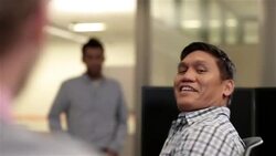 Two office-workers chat, toss toy football back and forth in cubicle Stock Footage