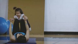 Young mother exercising with baby in gymnasium Stock Footage